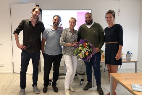 vijf mensen waarbij een persoon een bosje bloemen vasthoudt