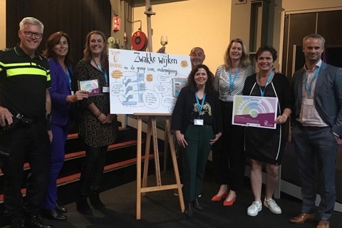 Acht mensen en een politieman staan met de Publieksaward Innovatiechallenge.