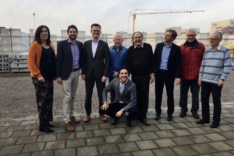 Groep mensen die staan en lachen voor de foto. 