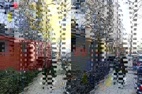 Twee mensen lopen hand in hand in een kwetsbare wijk.