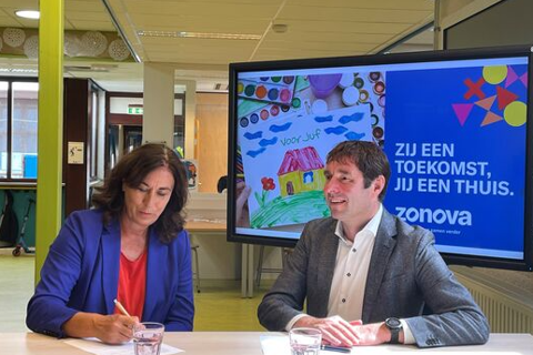 Twee mensen zitten aan tafel.