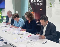 Foto van vier mensen die een ondertekening doen voor een nieuwbouwproject Brasa Village
