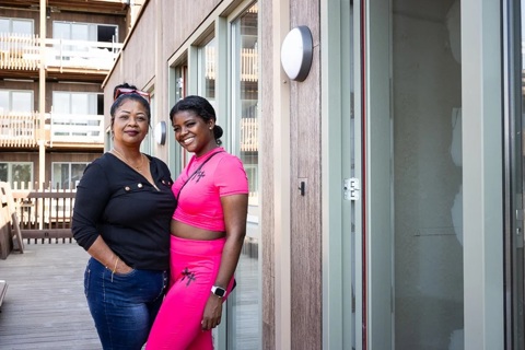 Twee vrouwen poseren op een galerij