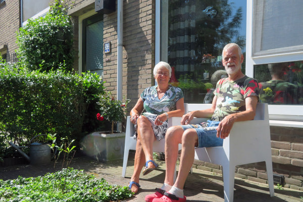 Twee bewoners zitten voor hun woning.