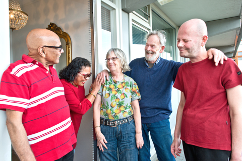 Vijf bewoners staan naast elkaar en lachen