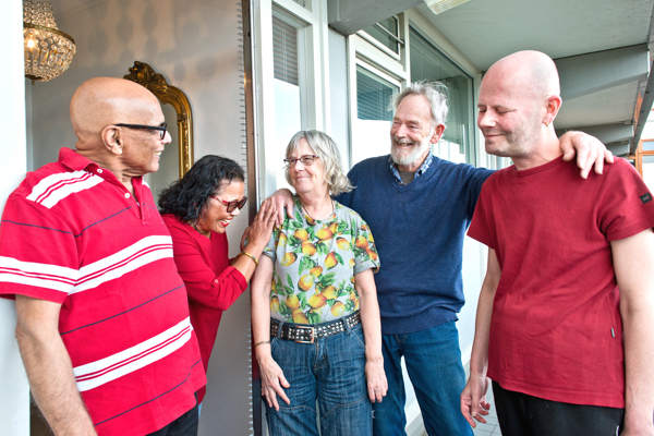 Vijf bewoners staan naast elkaar en lachen