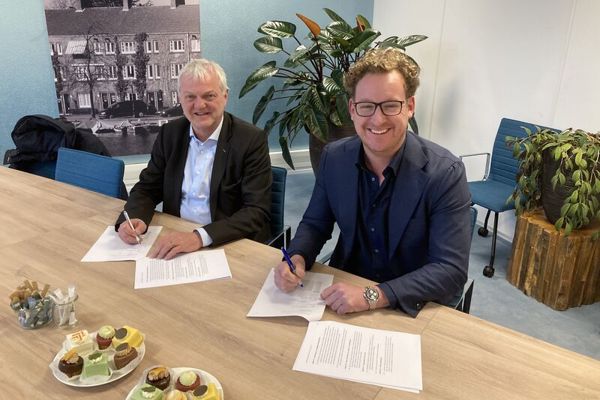 Twee mannen lachen tijdens tekenmoment Amstelkwartier