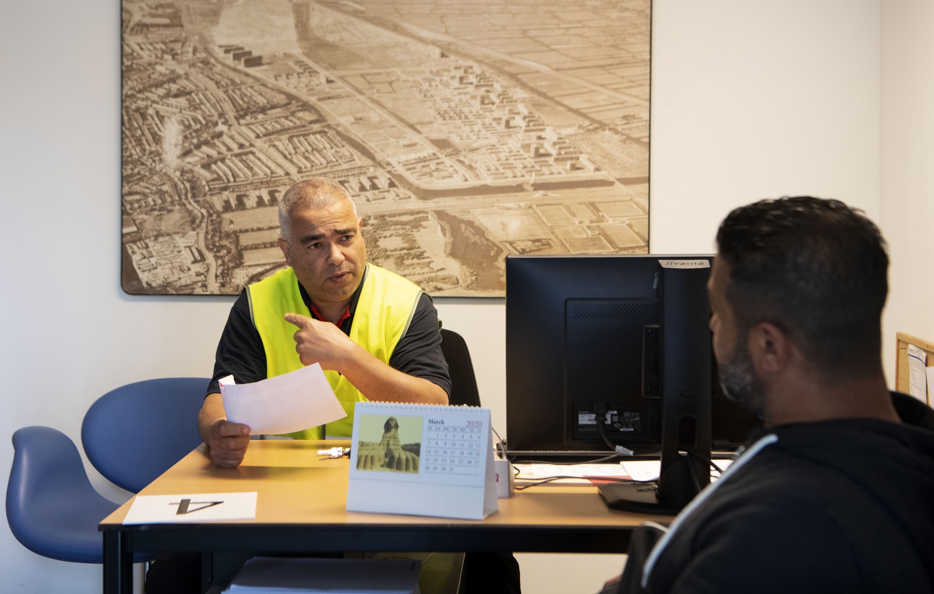 Foto van man komt bij wijkbeheerder voor advies
