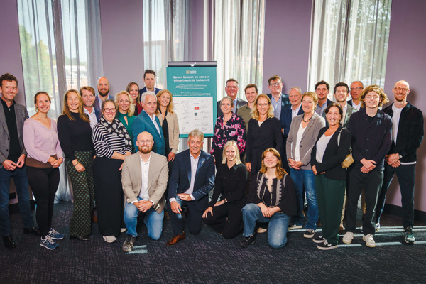 Groep betrokken mensen poseren voor ondertekening samenwerking