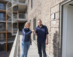 Een verhuurmakelaar overhandigt de sleutel aan een nieuwe bewoner